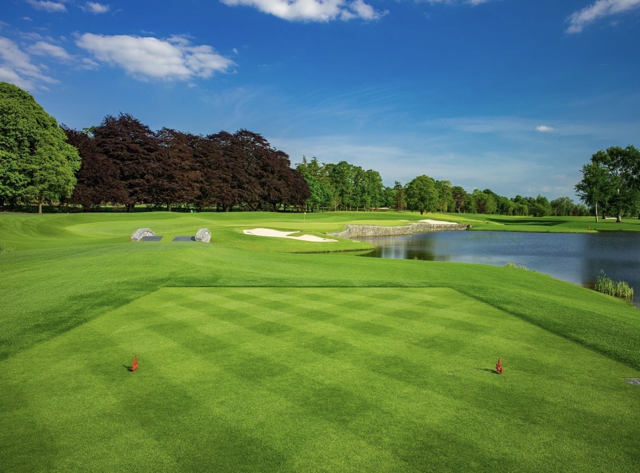 Adare Manor parkland tee looking over a lake and twin stone bridges to a bunkered green