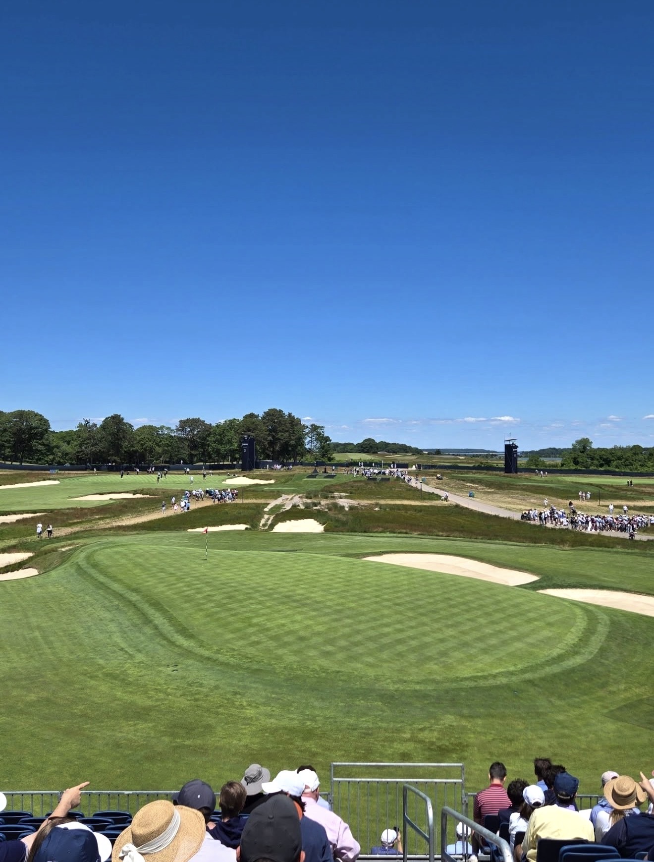 US Open championship green with bunkers and an estuary visible in the far distance
